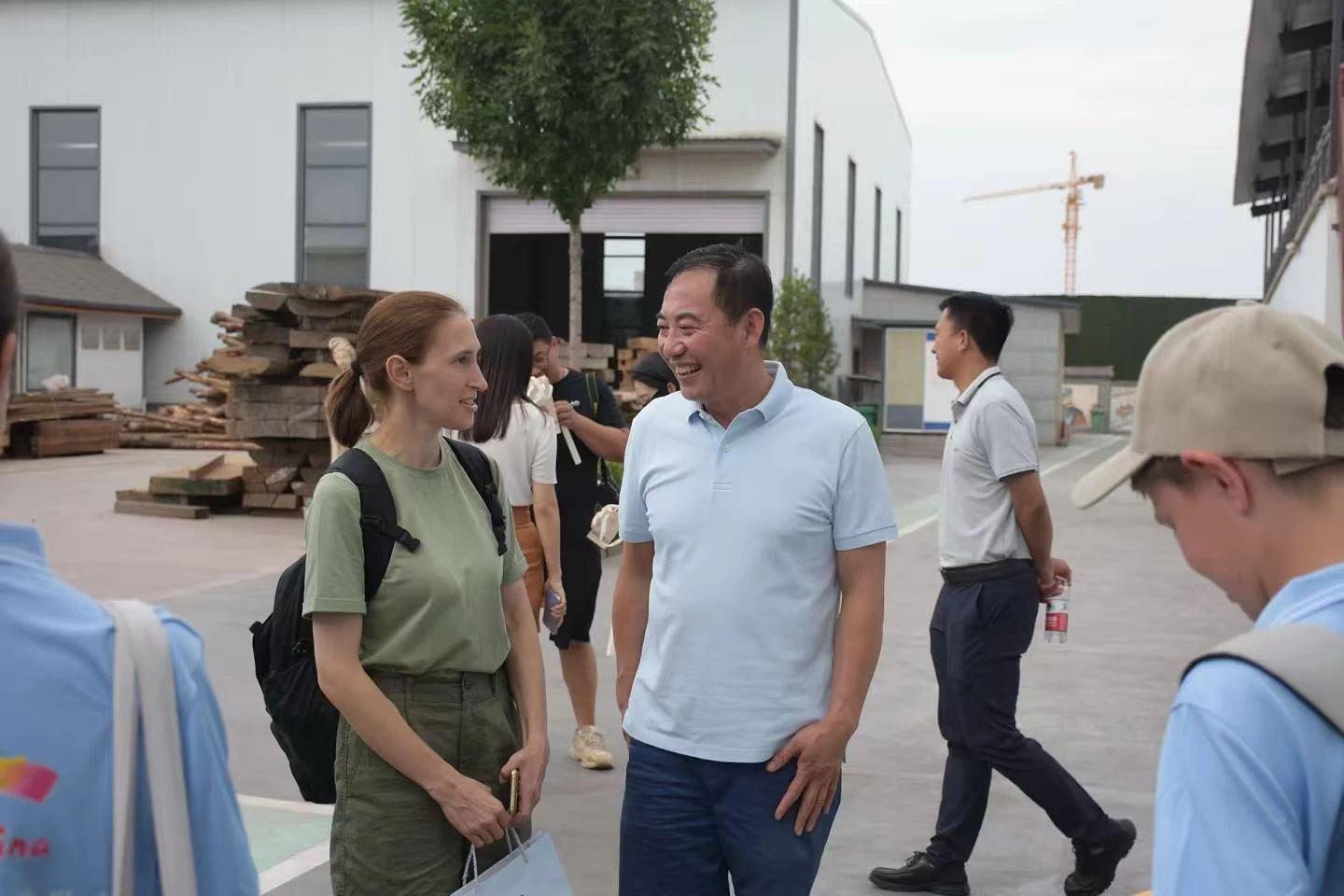荀建在木料加工基地与来访者交流